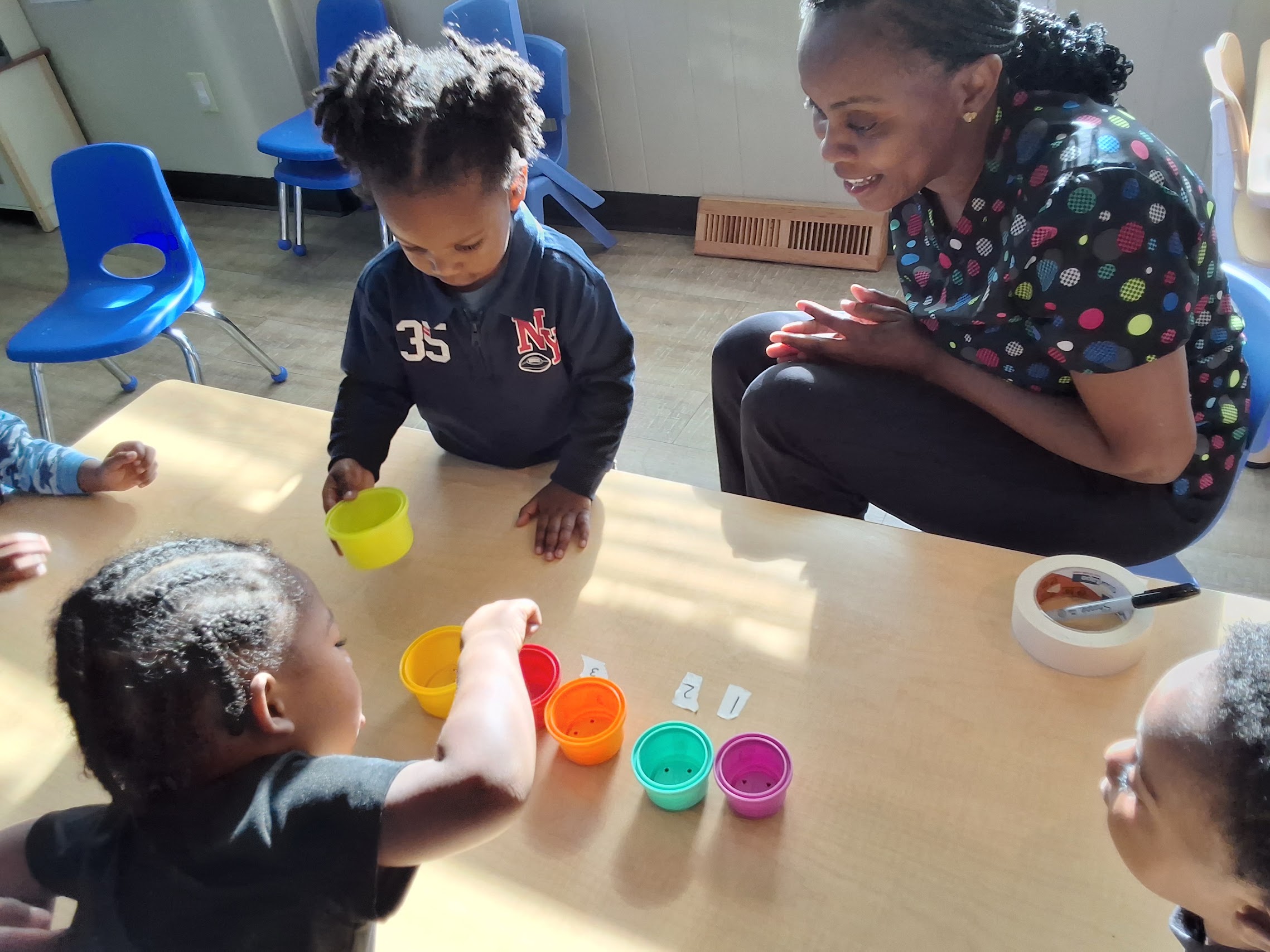 A teacher guiding children through a colorful counting activity