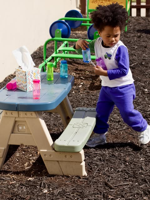 A child exploring and playing outdoors at My Little Angels Child Care